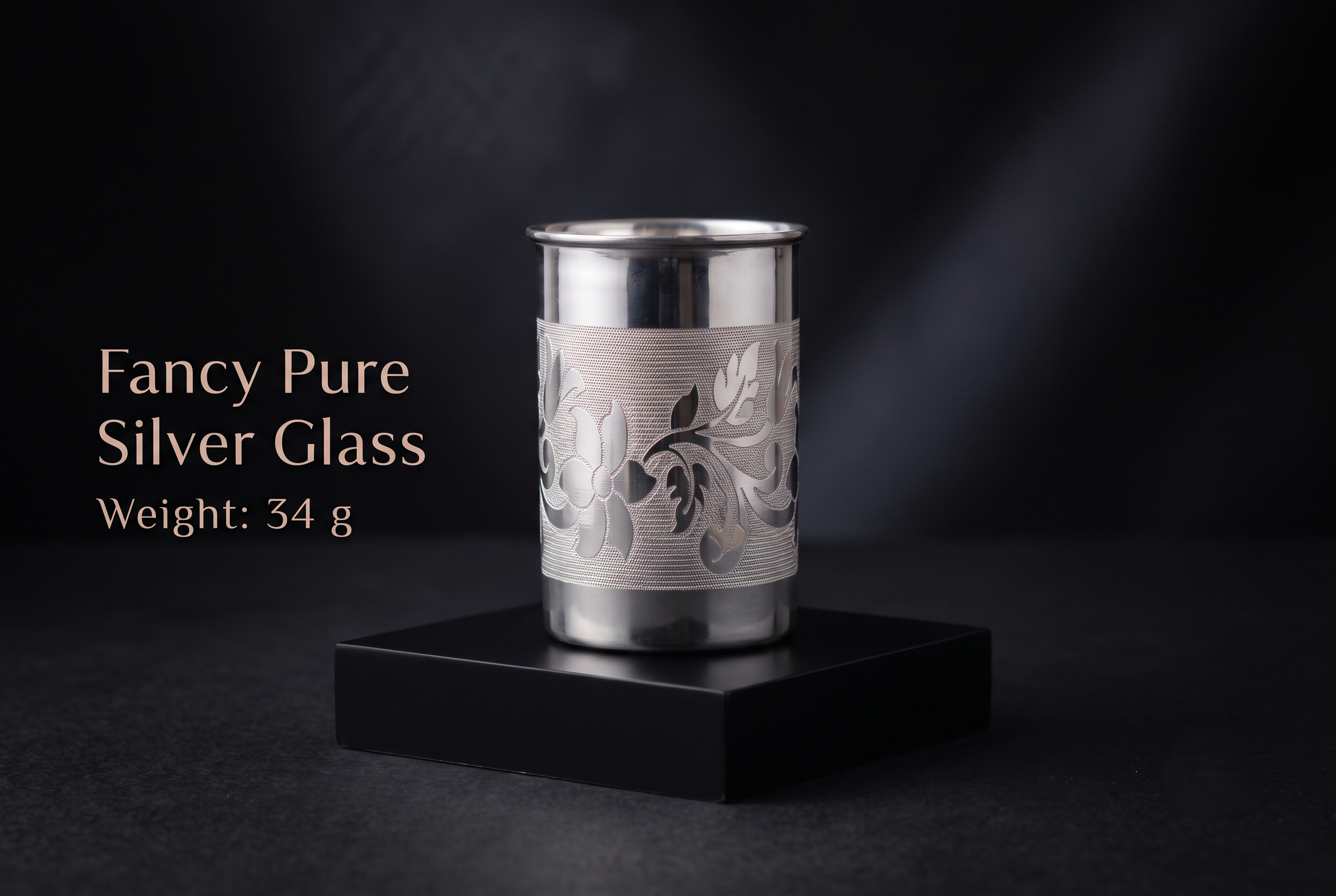 fancy-silver-glass-35gm Fancy Pure Silver Glass (34g) with intricate traditional floral engraving displayed on a luxury black display stand