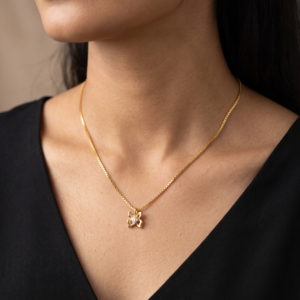 A woman wearing the delicate 16 inch Rajyan Jewellers 18K yellow gold butterfly pendant chain necklace