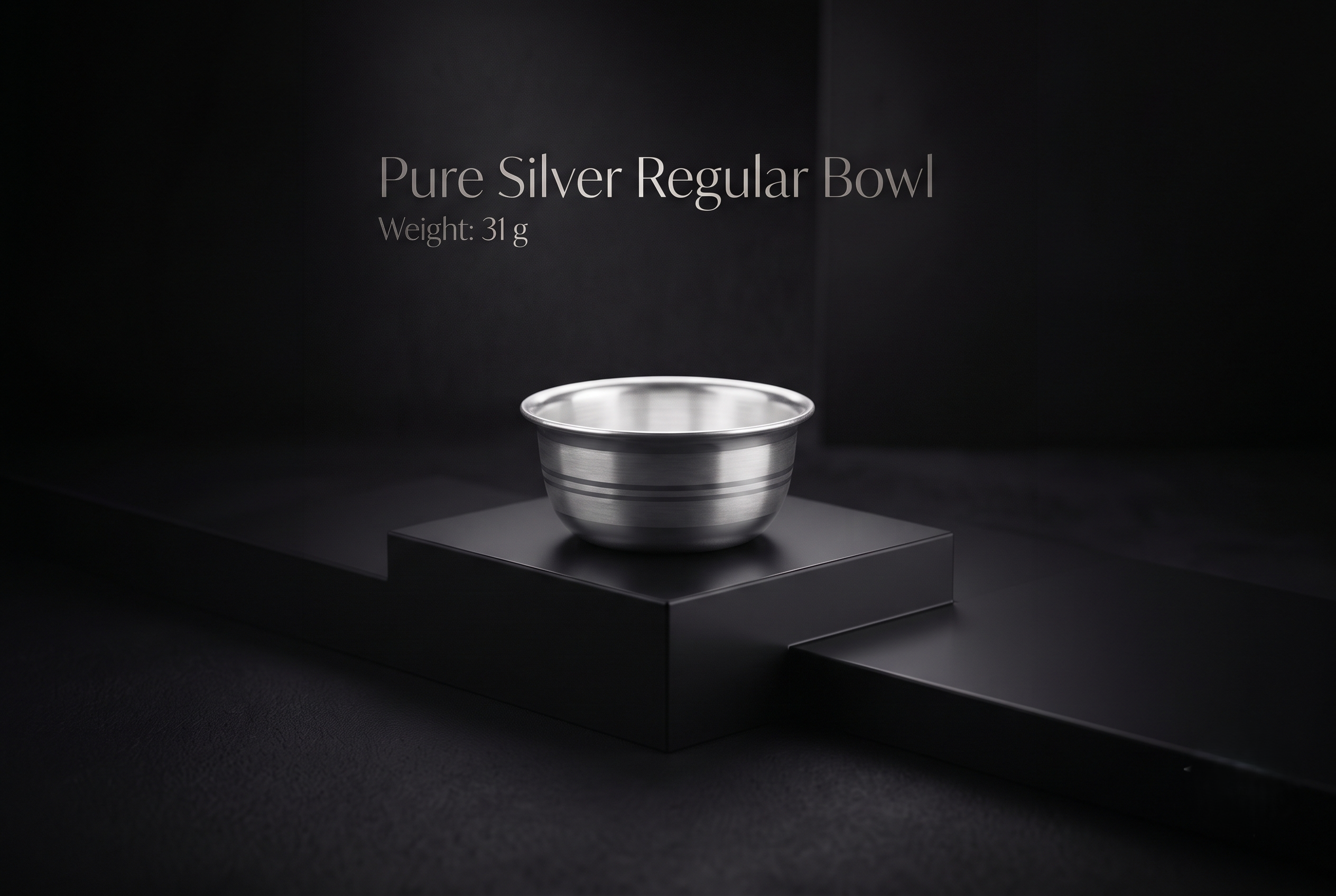 silver-bowl-31gm Pure silver regular bowl with dual horizontal engraved bands weighing 31 grams displayed on a matte black display stand