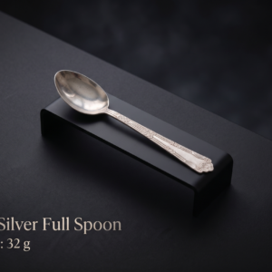 Pure silver spoon with intricate handle engravings, weight 32g, displayed on a matte black luxury stand.